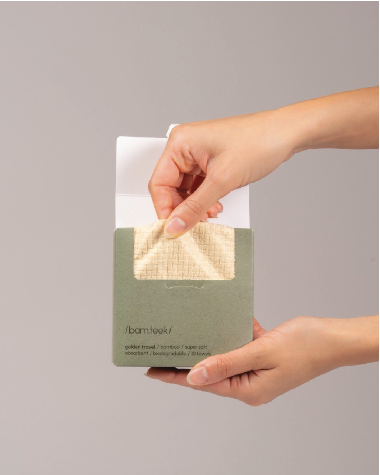 Golden Travel towel being pulled from packaging, showcasing its bamboo softness and single-use convenience.