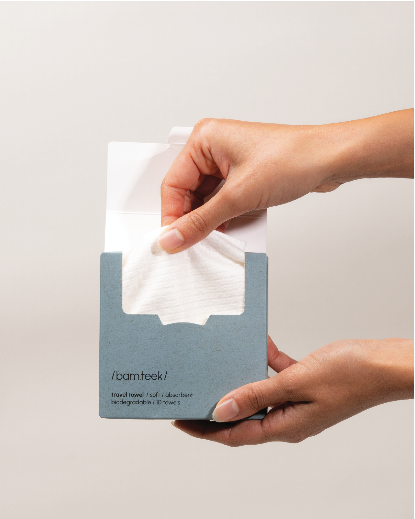 Person holding a Travel Towel from Bamteek in a biodegradable package.